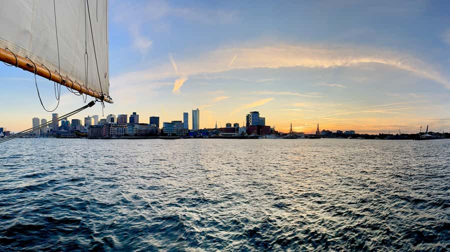 Boston: Sunset Tall Ship Harbor Cruise - Boston Harbor at golden hour: skyline views, cannon sounds, and contrails